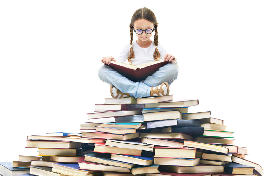 girl reading on pile of books